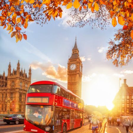 Buses with autumn leaves against Big Ben in London, England, UK